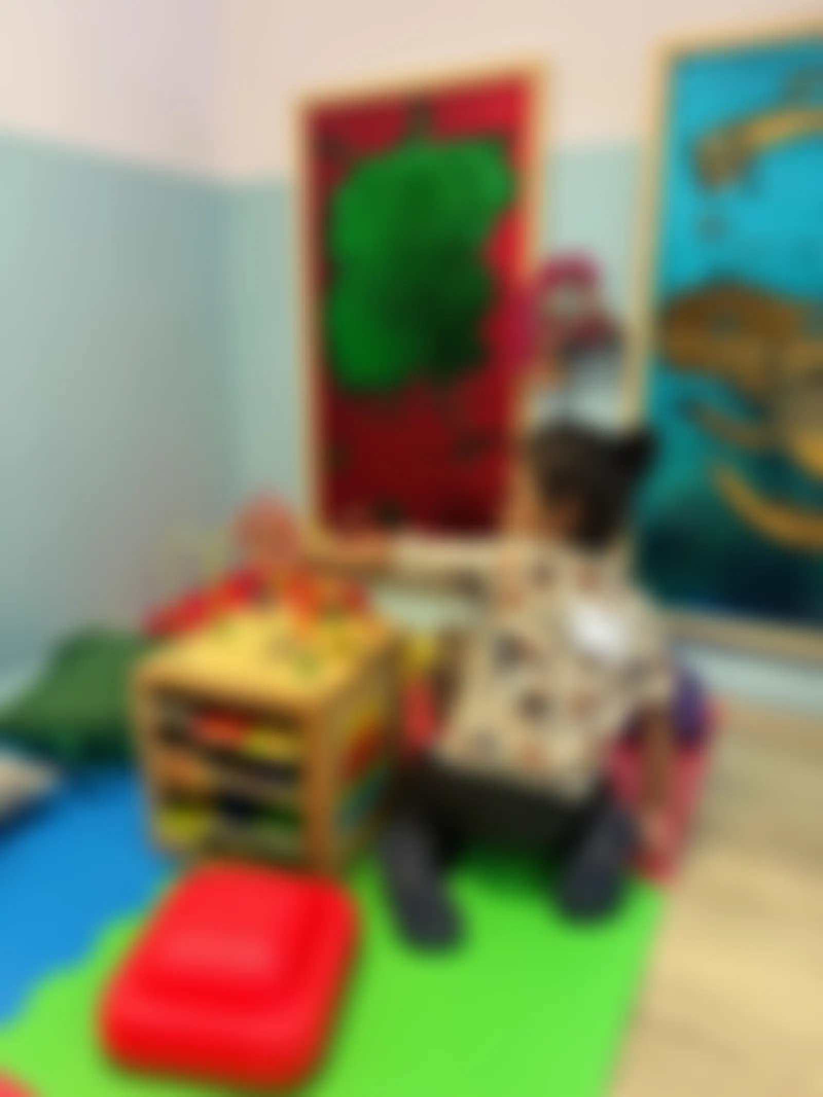 Child with an activity cube in front of the glitter sensory wall panels